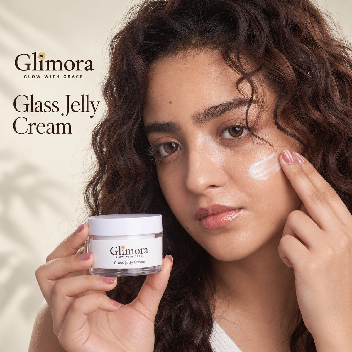 Model applying GLIMORA Glass Jelly Cream to her cheek while holding the jar.
